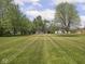 An expansive green lawn with clear sightlines to various buildings on the property and beyond at 4305 Clinton St, Lawrence, IN 46226