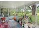 Enclosed sunroom with glass windows, featuring a variety of plants and garden-themed decor at 4305 Clinton St, Lawrence, IN 46226