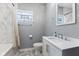 Updated bathroom with sleek vanity, mirror, and walk-in shower with marble-like tiling at 441 N Temple Ave, Indianapolis, IN 46201