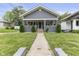 Charming single-story home featuring a manicured front yard with an inviting walkway and covered porch at 441 N Temple Ave, Indianapolis, IN 46201