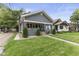 Charming single-story home featuring a manicured front yard with an inviting walkway and covered porch at 441 N Temple Ave, Indianapolis, IN 46201