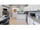 Well-lit modern kitchen with white cabinets, granite countertops, stainless steel appliances, and wood laminate floors at 441 N Temple Ave, Indianapolis, IN 46201