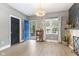 Bright living room featuring an open blue front door, lots of natural light, and sleek wood laminate floors at 441 N Temple Ave, Indianapolis, IN 46201