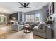 Bright and airy living room with a large comfortable couch, a ceiling fan, and wood laminate floors at 441 N Temple Ave, Indianapolis, IN 46201