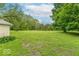 Expansive backyard featuring a large grassy lawn surrounded by mature trees and lush greenery, offering ample space for outdoor activities at 4526 Iowa St, Clayton, IN 46118