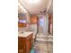 Bathroom featuring gray tiled walls, a wooden vanity, a toilet, and a shower-tub combo, offering a cozy design at 4526 Iowa St, Clayton, IN 46118