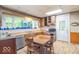 Cozy kitchen featuring wooden cabinetry, a stainless-steel dishwasher, and a dining area perfect for Gathering gatherings at 4526 Iowa St, Clayton, IN 46118