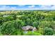 Aerial view showcases a luxurious home nestled among lush green trees against a blue sky at 4623 E Windsor Ln, Columbus, IN 47201