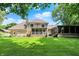 Expansive backyard showcasing a well-maintained lawn, screened in porch, and home's exterior at 4623 E Windsor Ln, Columbus, IN 47201