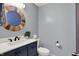 Stylish powder room featuring a modern vanity with round mirror and contemporary fixtures at 4623 E Windsor Ln, Columbus, IN 47201