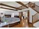 Bedroom with exposed beams, wood floors, fireplace, and views into the en suite bathroom via the open door at 4623 E Windsor Ln, Columbus, IN 47201