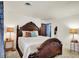 Bedroom with a wood-frame bed, soft lighting, and an open door revealing a view into another room at 4623 E Windsor Ln, Columbus, IN 47201