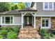Charming entryway with stone steps, stone accents, white pillars, and a glass front door at 4623 E Windsor Ln, Columbus, IN 47201