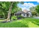 A view from the side of the house showcases the screened porch and mature landscaping at 4623 E Windsor Ln, Columbus, IN 47201