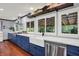 Contemporary kitchen featuring stainless steel appliances, white countertops, blue cabinetry, and a farmhouse sink at 4623 E Windsor Ln, Columbus, IN 47201