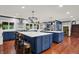 Spacious kitchen featuring two kitchen islands with quartz countertops and blue cabinets, stainless steel appliances, and hardwood floors at 4623 E Windsor Ln, Columbus, IN 47201
