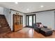Inviting living room with hardwood floors, a cozy chair, and a glass display cabinet by the staircase at 4623 E Windsor Ln, Columbus, IN 47201