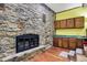 Living room featuring a stone fireplace, wooden floors, and convenient built-in bar at 4623 E Windsor Ln, Columbus, IN 47201