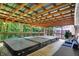 Covered patio featuring a hot tub with wood decking, an open ceiling, and an idyllic wooded view at 4623 E Windsor Ln, Columbus, IN 47201