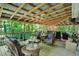 Inviting covered patio featuring wicker furniture, string lights, and a peaceful view of the surrounding nature at 4623 E Windsor Ln, Columbus, IN 47201