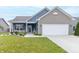Charming one-story home with blue siding, brick accents, well-kept lawn, and attached two-car garage at 485 Thunderwood Dr, Greenfield, IN 46140