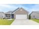 Home exterior featuring blue siding, a brick garage, and a manicured lawn at 485 Thunderwood Dr, Greenfield, IN 46140