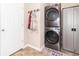 This laundry room includes a stacked washer and dryer, coat hooks and a storage cabinet at 485 Thunderwood Dr, Greenfield, IN 46140