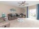 Inviting living room featuring comfortable seating, a ceiling fan, and access to the outdoor patio at 485 Thunderwood Dr, Greenfield, IN 46140