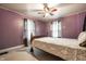 Bedroom with purple walls, ceiling fan, and two bright windows at 4912 Central Ave, Indianapolis, IN 46205