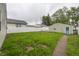 Backyard featuring a small patch of grass, a paved walkway, and a detached garage at 4933 W 13Th W St, Speedway, IN 46224