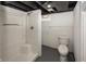 Basement bathroom with a fiberglass shower and toilet adjacent to unfinished walls at 4933 W 13Th W St, Speedway, IN 46224