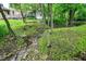 A small creek in a backyard with green grass and mature trees at 4990 E County Road 750 S, Brownsburg, IN 46112