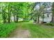 A backyard surrounded with mature trees, a small shed, and a charcoal grill at 4990 E County Road 750 S, Brownsburg, IN 46112