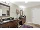A bathroom featuring double sinks with dark wood cabinets and granite countertops with a red and blue patterned rug at 4990 E County Road 750 S, Brownsburg, IN 46112