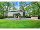 A metal pole barn features a covered porch with rocking chairs, set amidst lush greenery and a rock foundation at 4990 E County Road 750 S, Brownsburg, IN 46112
