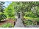 Charming gazebo featuring a decorative lattice door, surrounded by lush greenery and a wooden walkway at 4990 E County Road 750 S, Brownsburg, IN 46112
