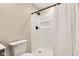 White tiled shower with black shower fixtures, toilet, and a white shower curtain in a bathroom setting at 515 Lynton Way, Westfield, IN 46074
