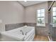 Bright bathroom with a soaking tub, large window, neutral walls, and modern fixtures at 515 Lynton Way, Westfield, IN 46074