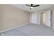A bright carpeted bedroom with a ceiling fan, a closet, and a door to the hallway at 515 Lynton Way, Westfield, IN 46074