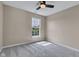 This comfortable carpeted bedroom features a lighted ceiling fan and a bright window at 515 Lynton Way, Westfield, IN 46074