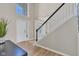 Bright foyer features hardwood floors, a staircase with dark railing, and natural light from the front door at 515 Lynton Way, Westfield, IN 46074