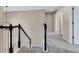 Carpeted hallway with white trim, neutral walls and black railing, featuring a modern chandelier and access to multiple rooms at 515 Lynton Way, Westfield, IN 46074