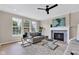 Comfortable living room featuring a fireplace, a ceiling fan, and lots of natural light from surrounding windows at 515 Lynton Way, Westfield, IN 46074
