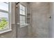 Modern bathroom featuring a glass-enclosed shower with sleek gray tile and a window providing natural light at 515 Lynton Way, Westfield, IN 46074
