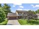 Two story home with brick and tan siding, long driveway, manicured lawn and mature landscaping at 5325 Ridge Hill Way, Avon, IN 46123