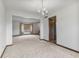 Open-concept living area with a chandelier, neutral carpet, and seamless transitions to other rooms at 5325 Ridge Hill Way, Avon, IN 46123