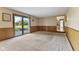 Bright living room with wood paneling, large sliding glass doors, and access to kitchen at 5325 Ridge Hill Way, Avon, IN 46123