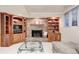Cozy basement with a brick fireplace, built-in shelving, and a glass coffee table at 5404 Cayman Dr, Carmel, IN 46033