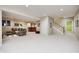 Open basement area with neutral carpet, featuring a bar area, comfortable seating, and a staircase at 5404 Cayman Dr, Carmel, IN 46033