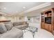 Finished basement area with a large sofa, glass table, and built-in entertainment center at 5404 Cayman Dr, Carmel, IN 46033